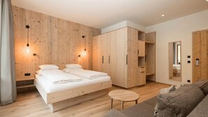 Un dormitorio moderno con pared de madera, cama, armario y sofá.