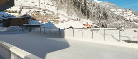 Pista de esquí cubierta de nieve con estructuras de madera y cielo despejado.