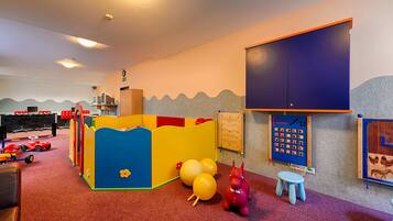 Children can play and learn in this cozy space with a playpen, toys, and educational panels.