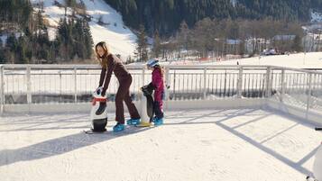 A snowy outdoor area with a fenced enclosure, likely a ski or snowboarding area.