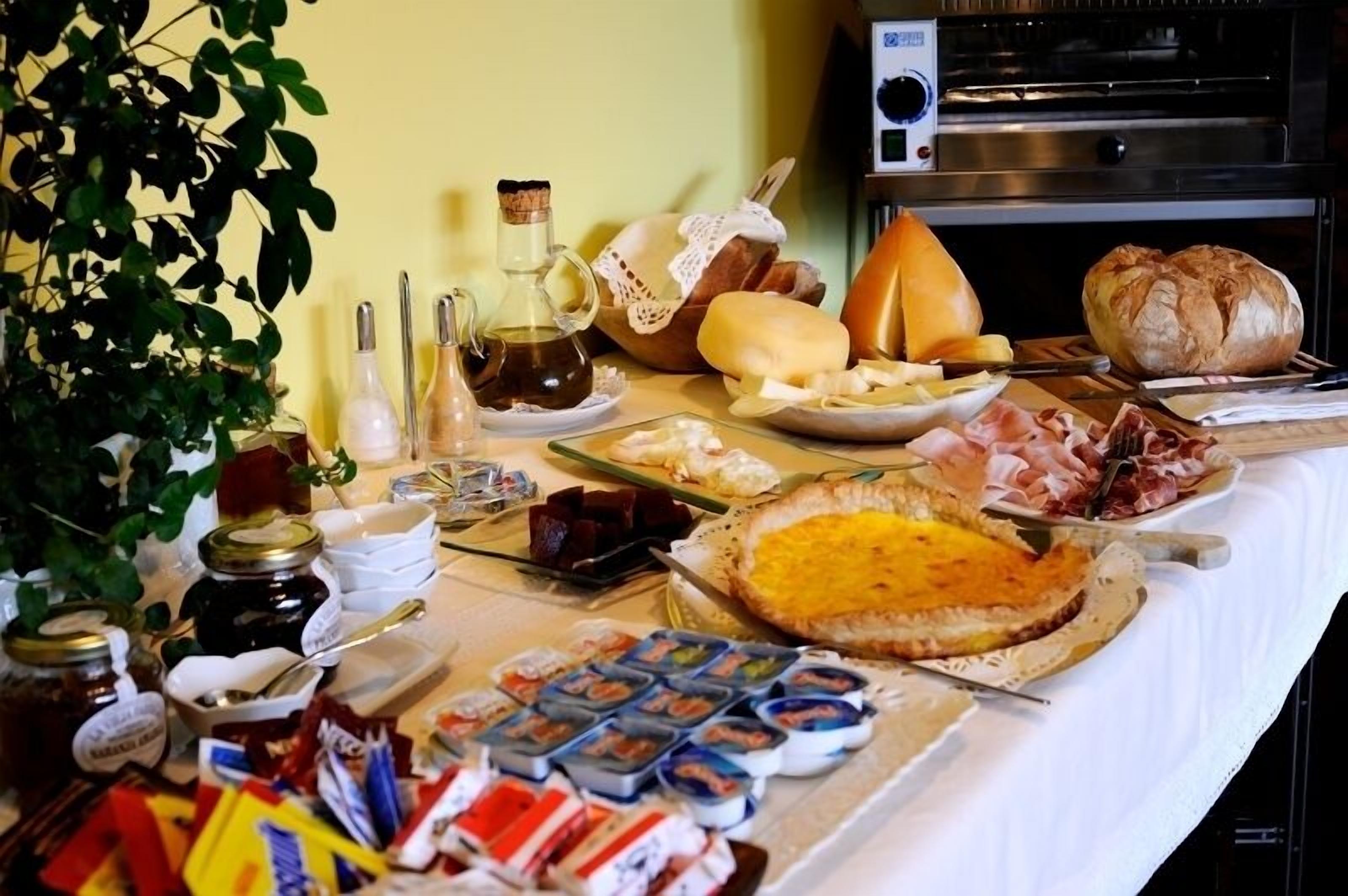 A buffet table with various food items including bread, cheese, and meats.