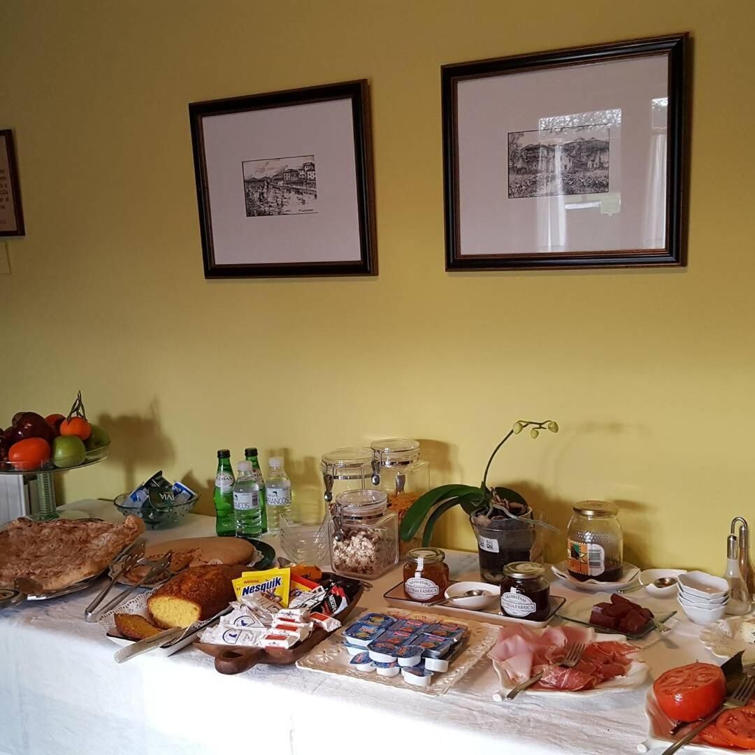 A buffet table with various food items, including fruits, cheeses, and condiments.