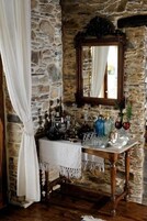Un muro de piedra con una mesa de madera y un espejo.