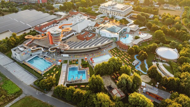 Vue aérienne d’un complexe hôtelier doté d’un parc aquatique, de plusieurs piscines et d’un grand bâtiment à étages.
