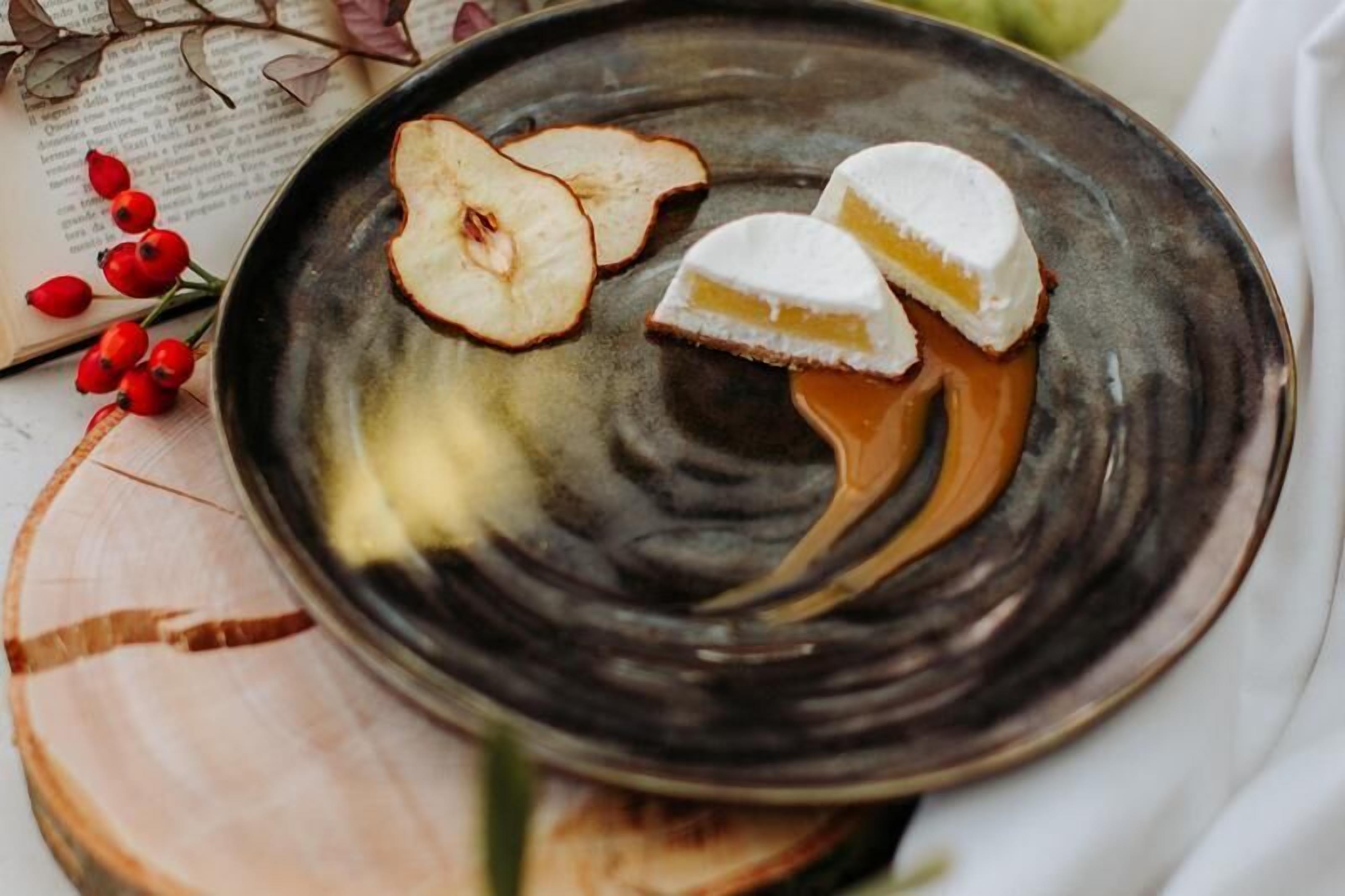 Un plato con postre, un libro y algunas bayas.