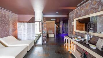 A modern hotel lobby with a reception desk, seating area, and a view into the room.