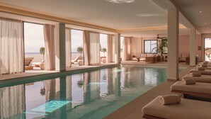 A pool area with lounge chairs and a view of the sea. - Besai Ibiza Boutique Hotel - New Opening (Sant Josep de sa Talaia)