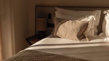 Una habitación de hotel con cama, mesita de noche y lámpara.