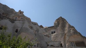 A building with unique rock-cut architecture, featuring multiple levels and windows. - Arif Cave Hotel (Nevsehir)