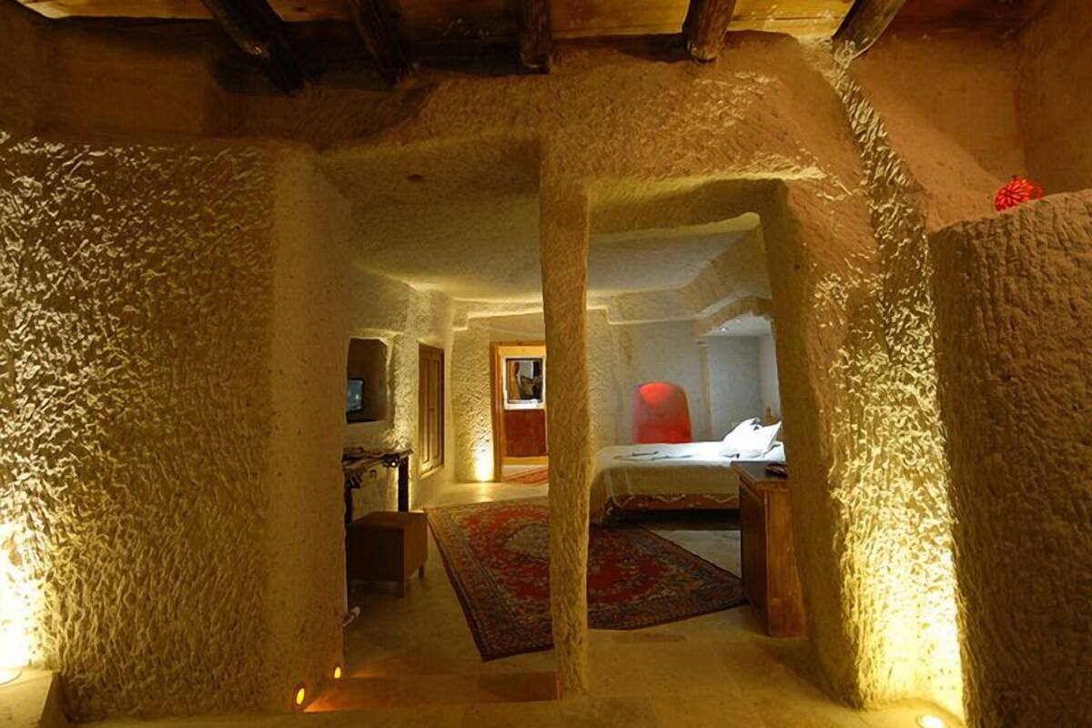 A cozy, rustic room with a bed, a red chair, and a wooden desk.