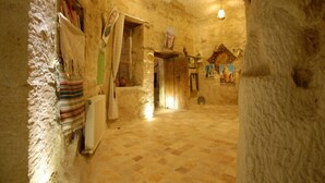 A rustic interior with stone walls, a checkered floor, and a small altar with religious icons. - Arif Cave Hotel (Nevsehir)