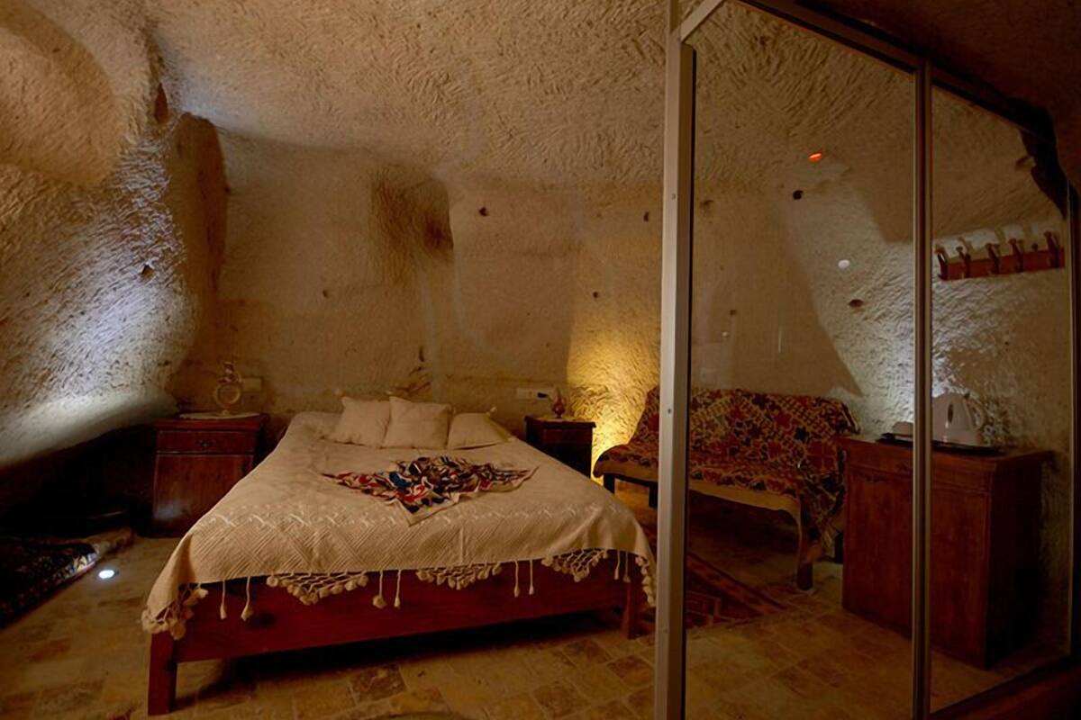 A cozy bedroom with a bed, a bedside table, and a chair.