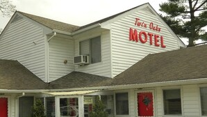 A Twin Oaks Motel with a white exterior, red accents, and a visible office window. - Twin Oaks Motel (Manasquan)