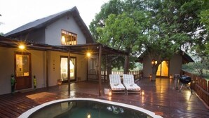 A wooden deck with a hot tub, lounge chairs, and a covered seating area. - Ngama Tented Safari Lodge (Hoedspruit)