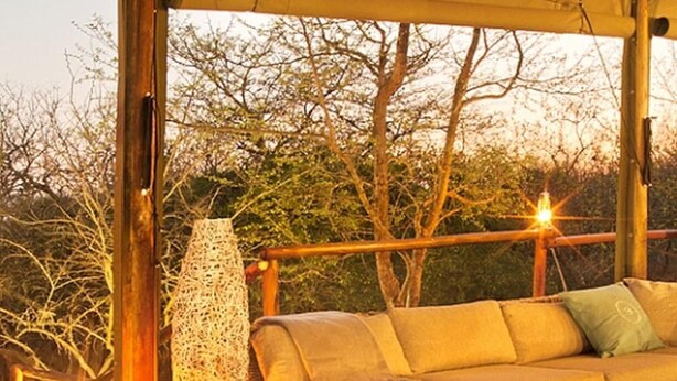A wooden deck with wicker furniture and a large vase. - Ngama Tented Safari Lodge (Hoedspruit)