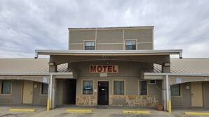 A motel with a sign indicating "MOTEL OFFICE" and a "VACANCY" sign.