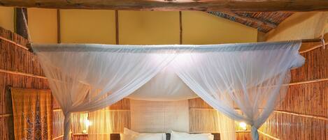 A bed with a canopy, wooden walls, and a patterned floor.