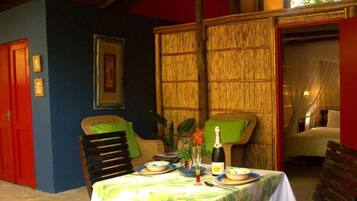 Comedor con una mesa dispuesta para dos, con mantel de temática tropical.