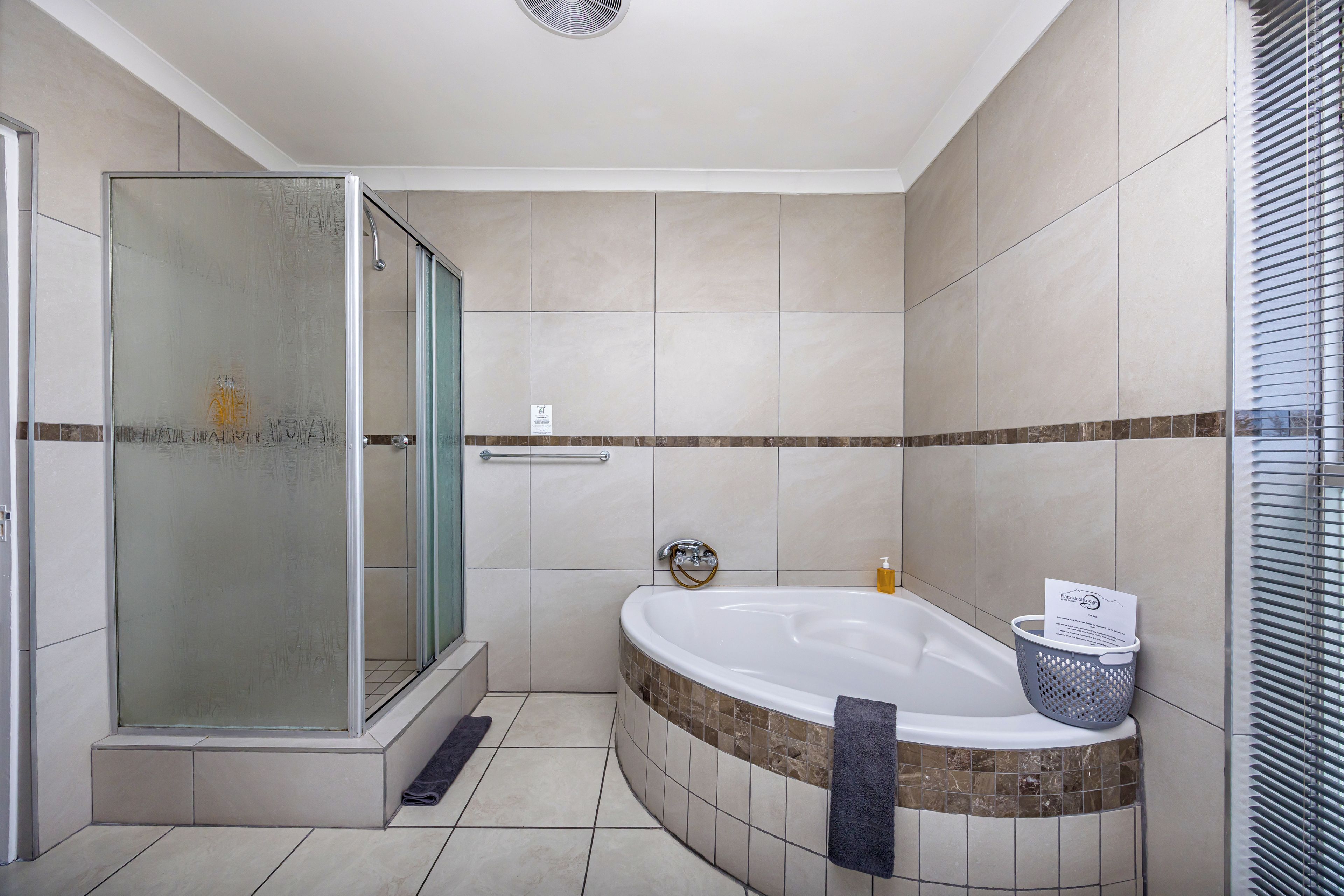 A modern bathroom with a glass-enclosed shower, a freestanding bathtub, and a tiled floor.