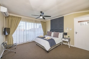 Ein Hotelzimmer mit Bett, Nachttisch und Deckenventilator.
