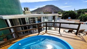 A pool on a wooden deck with a mountain view in the background. - Apartamento do Sol (Bombinhas)