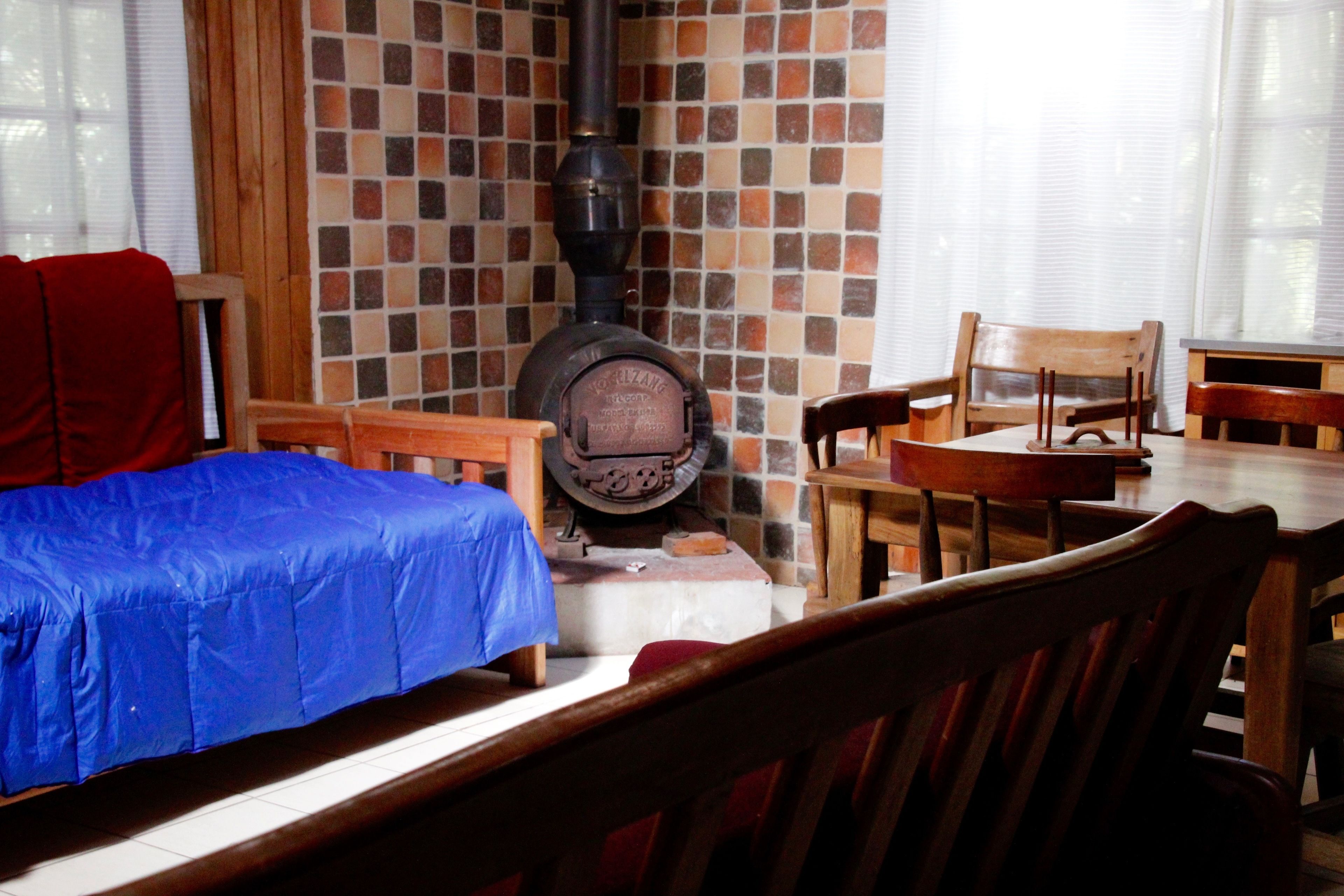 A cozy room with a bed, a fireplace, and wooden furniture.