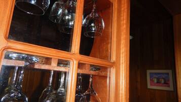 Un mueble de madera con varios vasos de vino colgando en su interior.