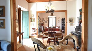 A dining area with a wooden table, chairs, and a chandelier. - Casa das Rendufas (Torres Novas)