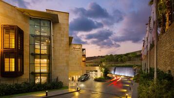 A hotel entrance with a modern design, a visible sign, and a waterfall feature.