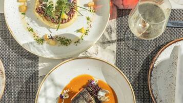 A table with various dishes, glasses, and a small potted plant.