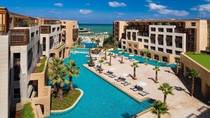 Un resort con piscina central, varios balcones y vistas al océano.