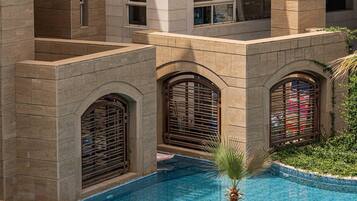 A swimming pool with arched windows and a palm tree in the center.