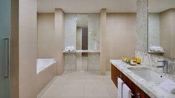 A modern bathroom with a large sink, mirror, and a shower area.