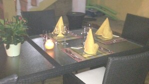 A dining table set with yellow napkins, wine glasses, and cutlery. - Casa Lilly B&B Cabarete (Cabarete)