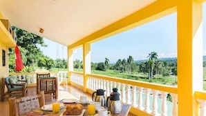 A breakfast setup on a balcony with a view of a green landscape. - Casa Lilly B&B Cabarete (Cabarete)