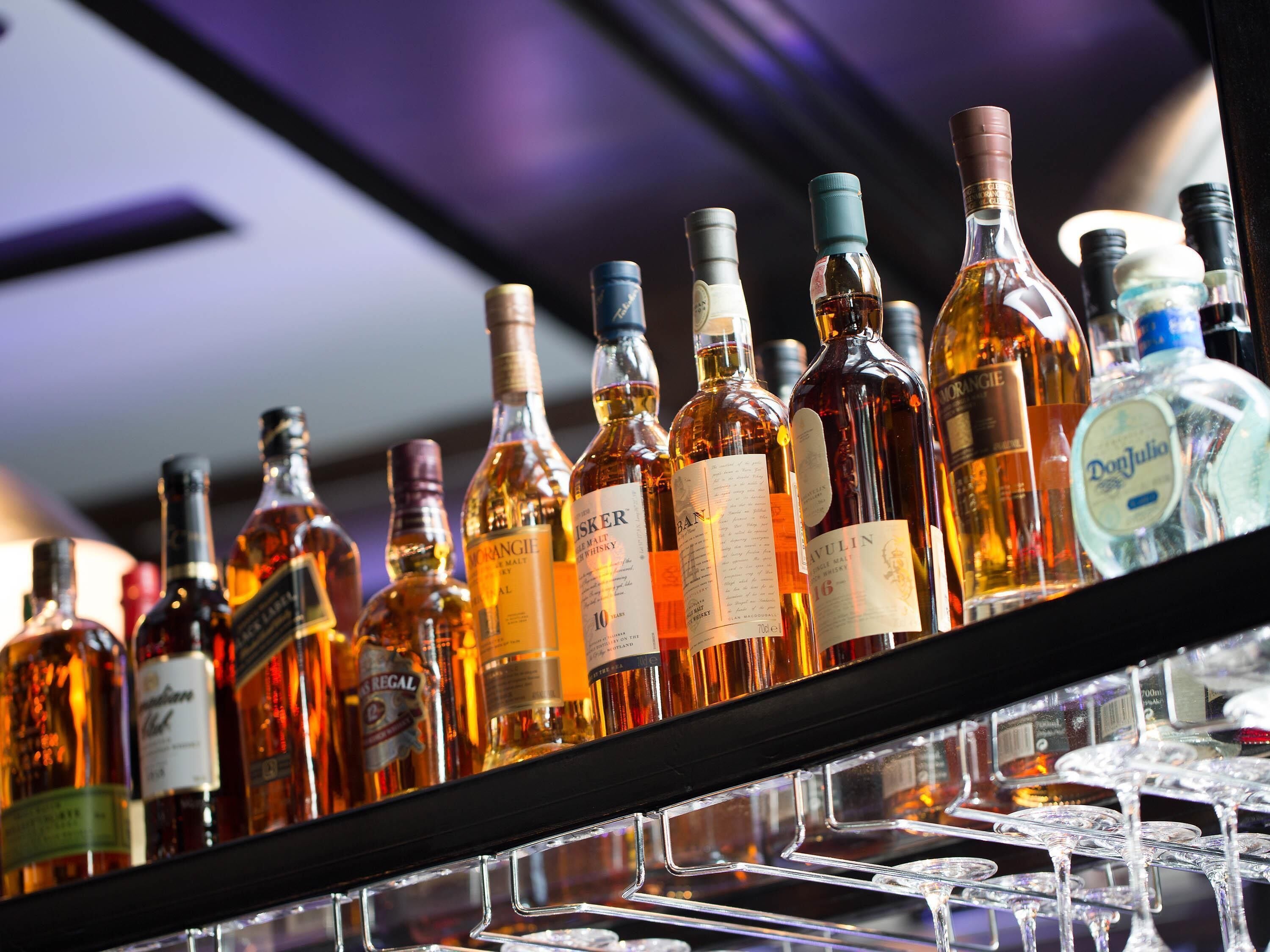 A variety of liquor bottles on a shelf.