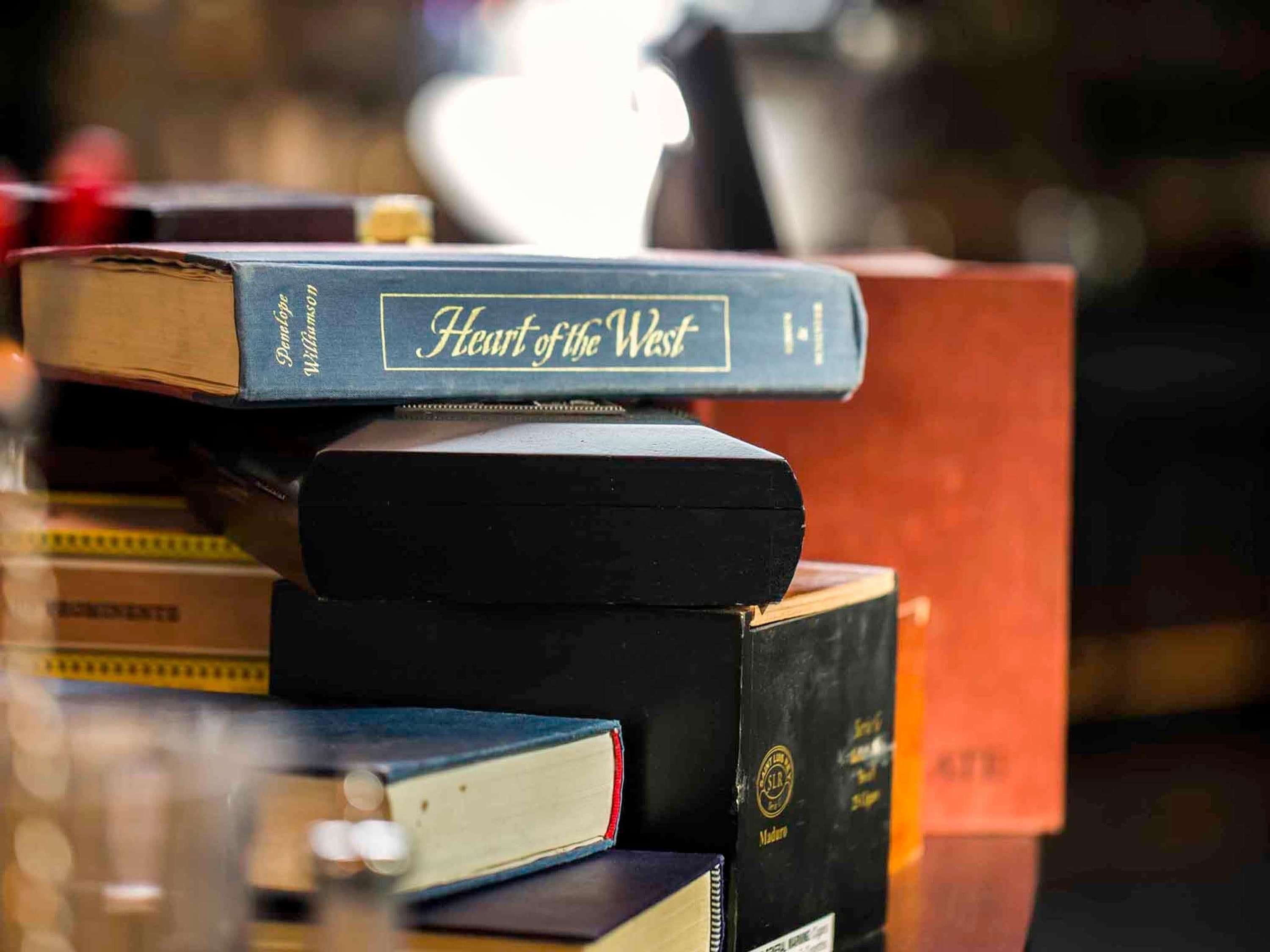 A stack of books with visible titles and spines.