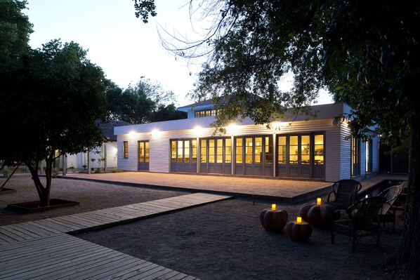 A modern building with large windows, a covered patio, and outdoor seating. - Noi Blend Colchagua (Palmilla)