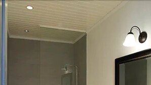 A modern bathroom with a glass-enclosed shower, a toilet, and a marble sink vanity.