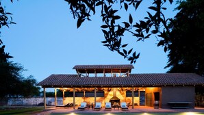 A modern house with a covered patio, outdoor seating, and a swimming pool.