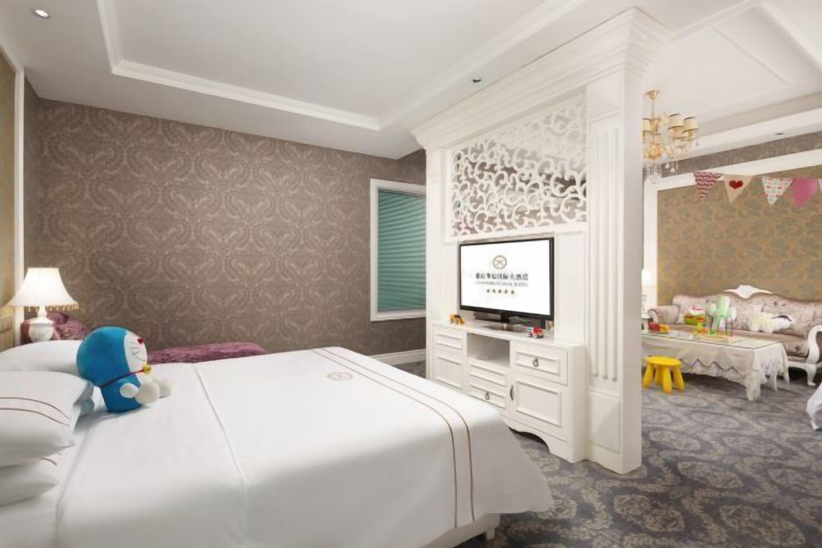 A hotel room with a bed, a TV, a dresser, and a sofa.