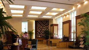 Eine Hotelhalle mit Check-in-Schalter, Sitzgelegenheiten und einer Wand mit Musterdesign.