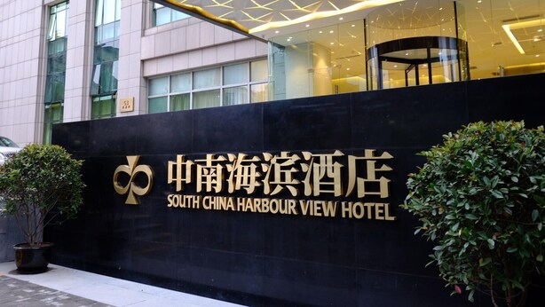 Das Hotel South China Harbour View: ein modernes Gebäude mit großer Fensterfront und einem markanten Eingangsbereich.