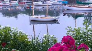 En lystbådehavn med flere både i havnen, omgivet af grønt og blomster.