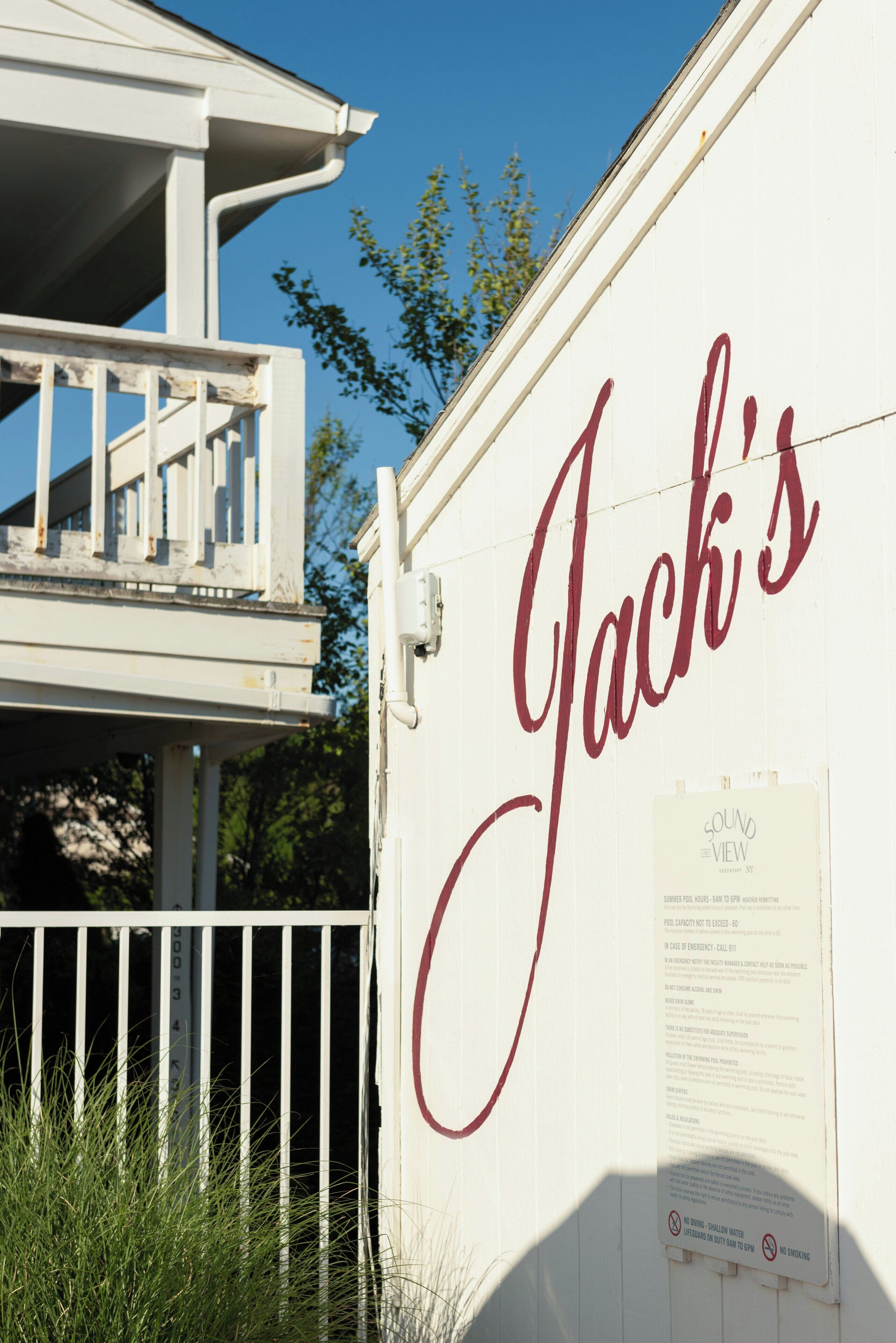 A white building with a sign reading 'Jack's' in cursive.
