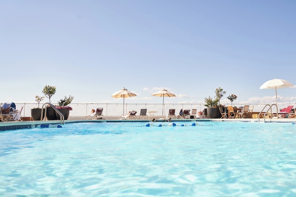Piscina a l'aire lliure de temporada, para-sols i gandules
