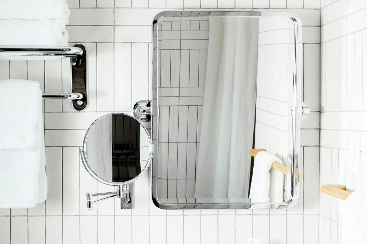 A bathroom with a white sink, a mirror, a towel rack, and a toilet.