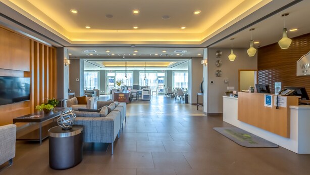 A spacious lobby with a reception desk, seating area, and a large TV screen. - Wingate by Wyndham Loveland (Loveland)