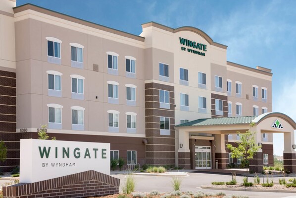 A multi-story hotel with a beige and brown facade, a prominent 'Wingate by Wyndham' sign, and a covered entrance. - Wingate by Wyndham Loveland (Loveland)