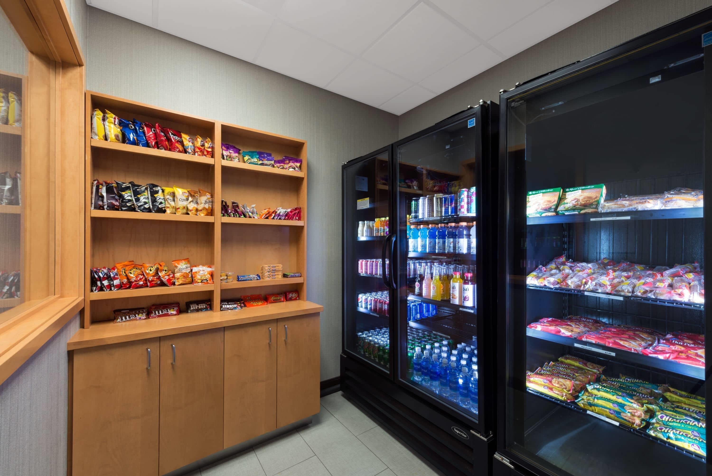 Un área de venta automática con estantes llenos de diversos aperitivos y una sección refrigerada con bebidas embotelladas.